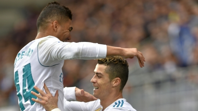 Real Madrid's Portuguese forward Cristiano Ronaldo (R) celebrates with Real Madrid's Brazilian midfielder Casemiro after scoring a goal during the Spanish league football match between Eibar and Real Madrid at the Ipurua stadium in Eibar on March 10, 2018. / AFP PHOTO / ANDER GILLENEA