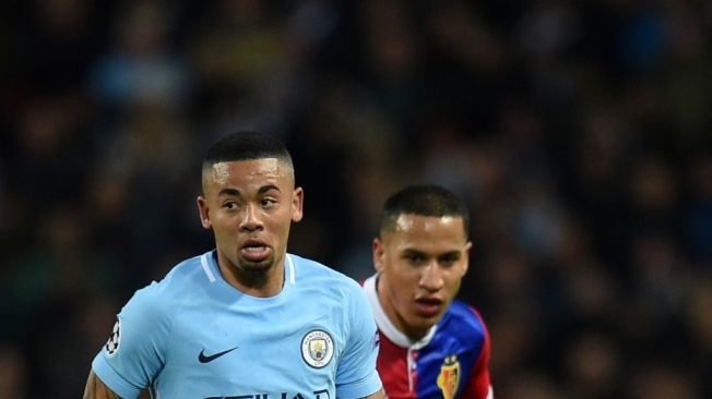 Manchester City's Brazilian striker Gabriel Jesus (L) vies with Basel's Swiss defender Leo Lacroix during the UEFA Champions League round of sixteen second leg football match between Manchester City and Basel at the Etihad Stadium in Manchester, north west England, on March 7, 2018. / AFP PHOTO / Oli SCARFF