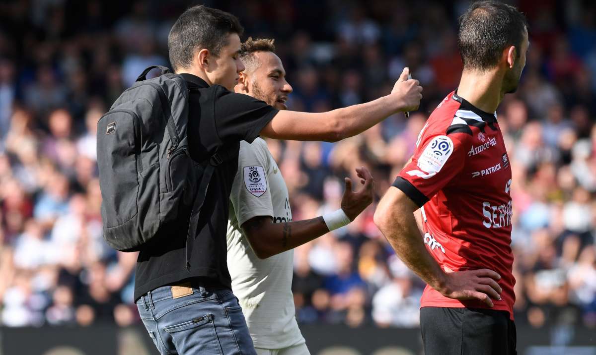 A pitch invader takes a selfie (L) with Paris Saint-Germain's Brazilian forward Neymar during the French L1 football match between Guingamp and Paris Saint-Germain, at the Roudourou stadium in Guingamp on August 18, 2018. / AFP PHOTO / FRED TANNEAU
