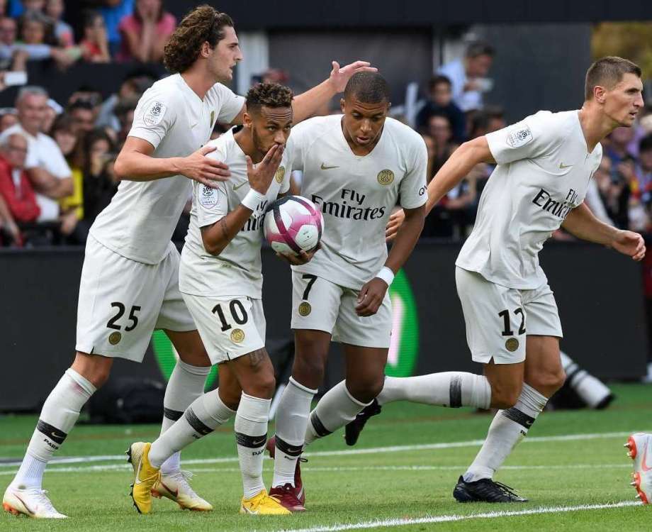 Paris Saint-Germain's Brazilian forward Neymar (2ndL) celebrates with Paris Saint-Germain's French midfielder Adrien Rabiot (L), Paris Saint-Germain's French forward Kylian Mbappe (2ndR) and Paris Saint-Germain's Belgian defender Thomas Meunier after scoring during the French L1 football match between Guingamp and Paris Saint-Germain, at the Roudourou stadium in Guingamp on August 18, 2018. / AFP PHOTO / FRED TANNEAU
