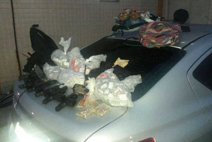 Um dos carros recuperados e as armas apreendidas com os bandidos após o tiroteio na Via Dutra