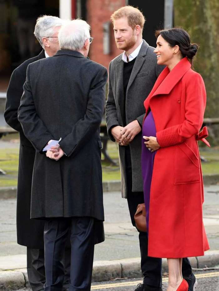 Britain's Prince Harry, Duke of Sussex (2L) and Meghan, Duchess of Sussex (R) are greeted as they arrive to visit Birkenhead, northwest England on January 14, 2019. (Photo by Paul ELLIS / AFP)