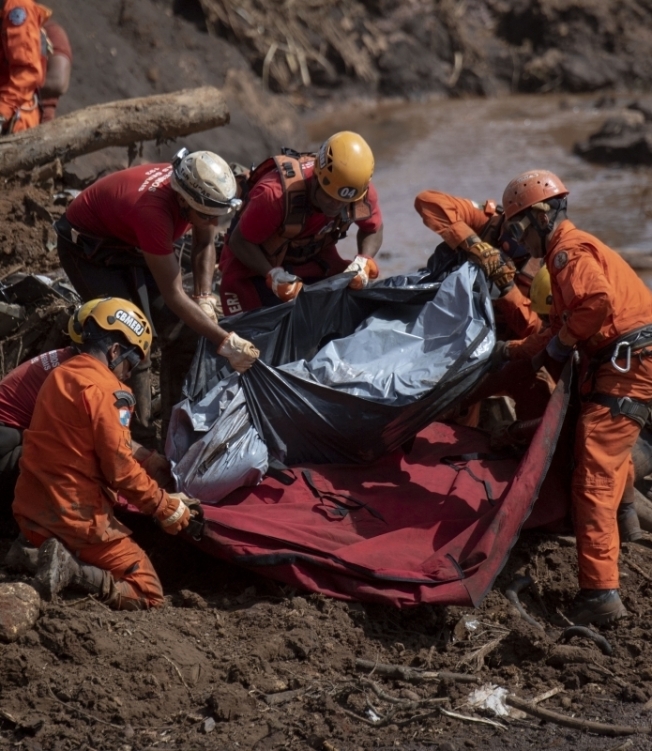 Firefighters recover the body of a victim of Friday's dam collapse at an iron-ore mine belonging to Brazil's giant mining company Vale near the town of Brumadinho, state of Minas Gerais, southeastern Brazil, on January 28, 2019. - The search for survivors intensified on Monday, on its fourth day, with the support of an Israeli contingent, after communities were devastated by a dam collapse that killed at least 60 people -- with hopes fading for 292 still missing. A barrier at the site burst on Friday, spewing millions of tons of treacherous sludge and engulfing buildings, vehicles and roads. (Photo by Mauro PIMENTEL / AFP)
