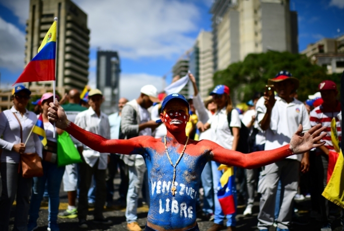 Supporters of Venezuelan opposition leader Juan Guaido wait to take part in a rally in Caracas, on February 23, 2019. - Venezuela braced for a showdown between the military and regime opponents at the Colombian border on Saturday, when self-declared acting president Juan Guaido has vowed humanitarian aid would enter his country despite a blockade. (Photo by RONALDO SCHEMIDT / AFP)
