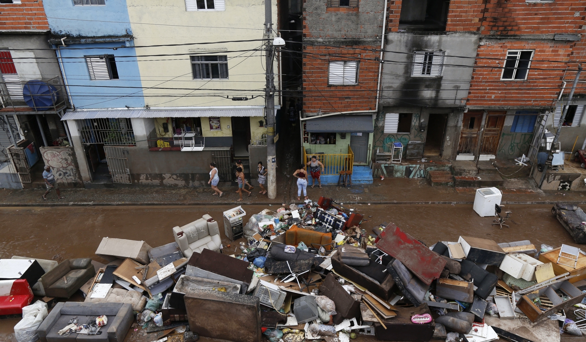 Móveis no meio da rua dão ideia da destruição causada pela chuva

