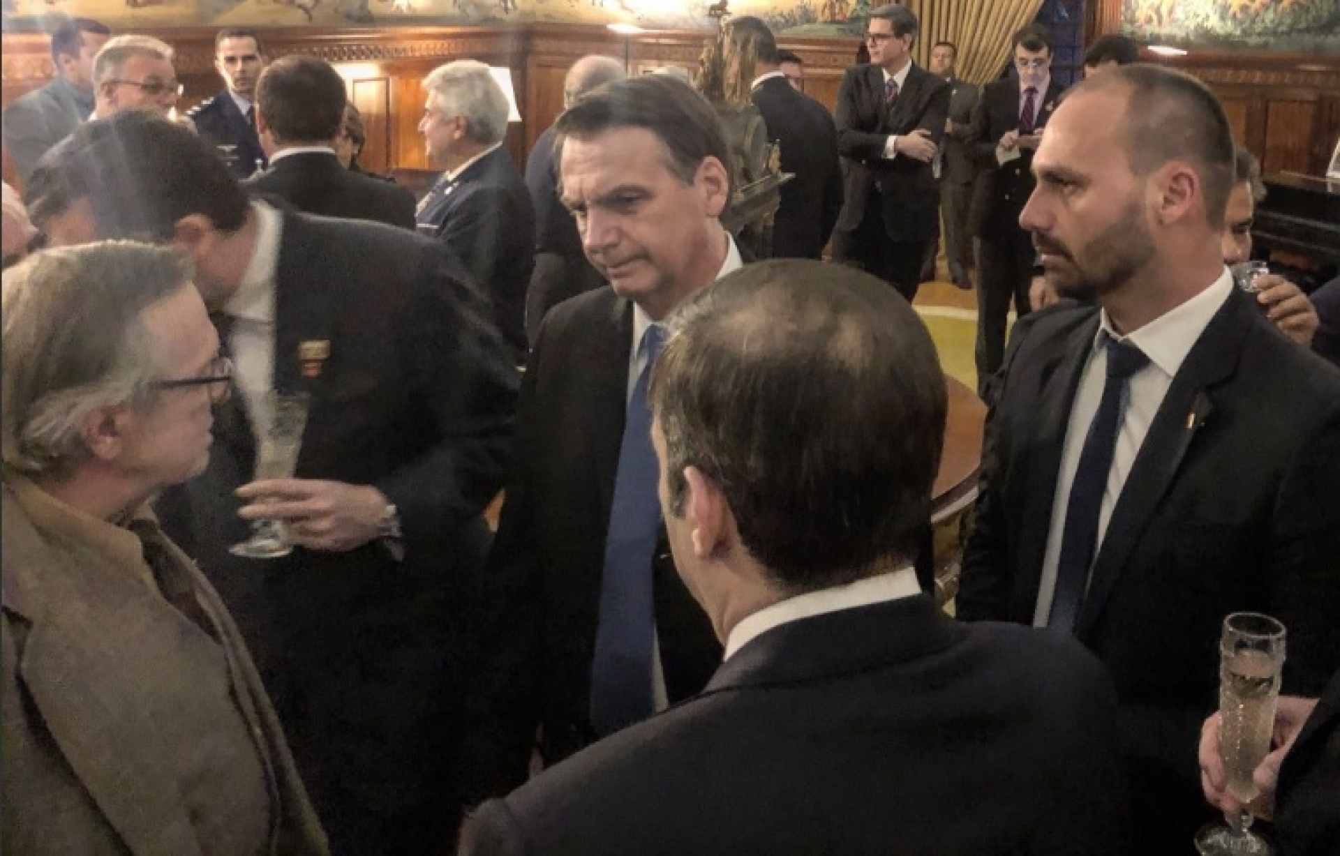 Presidente Jair Bolsonaro, deputado federal Eduardo Bolsonaro (PSL-SP) e o escritor Olavo de Carvalho em um jantar em Washington.