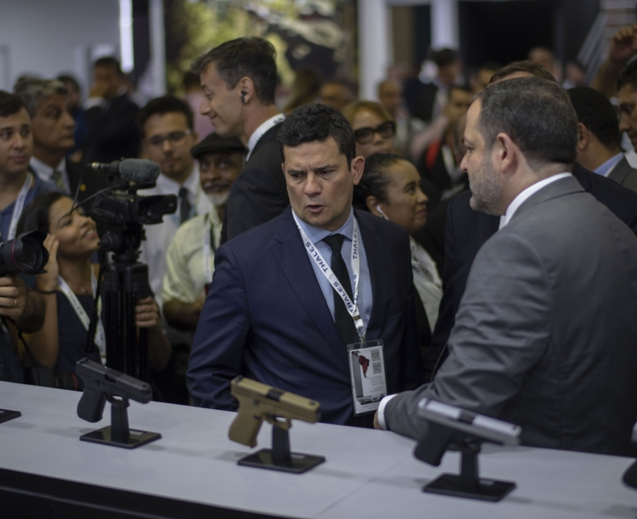 Brazilian Justice Minister Sergio Moro (C) looks at guns during the Defence and Security International Fair Exhibition (LAAD 2019) at Riocentro Expo Centre in Rio de Janeiro, Brazil, on April 2, 2019. (Photo by Mauro PIMENTEL / AFP)
      Caption