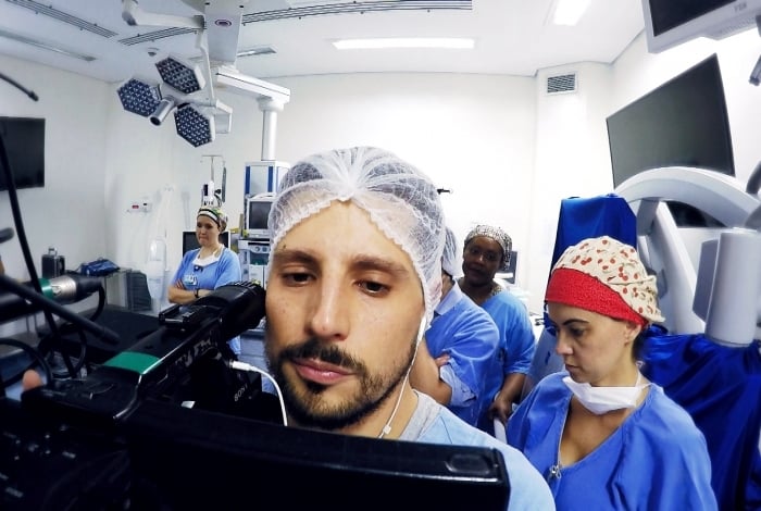 O repórter Erik von Poser se prepara para acompanhar uma das cirurgias das gêmeas