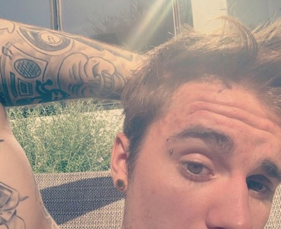 Justin Bieber com placa de diamentes e piercing na sobrancelha 