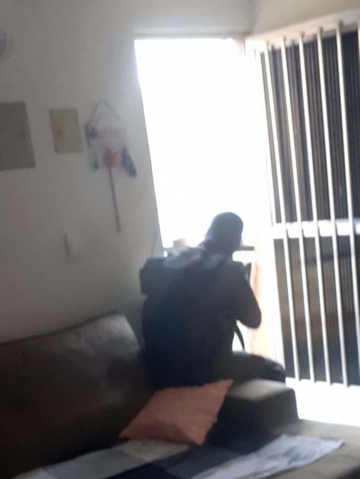 PM sentado em sofá de morador do Alemão dispara contra bandidos