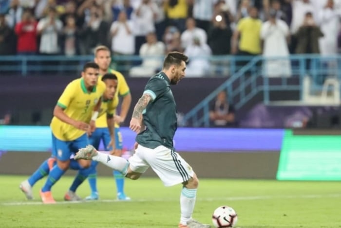 O craque Lionel Messi cobra o pênalti, que foi defendido por Alisson, mas o camisa 10 marcou no rebote