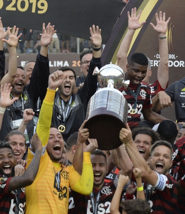 Players of Brazil's Flamengo celebrate on the podium with the trophy after winning the Copa Libertadores final football match by defeating Argentina's River Plate, at the Monumental stadium in Lima, on November 23, 2019. (Photo by Ernesto BENAVIDES / AFP)