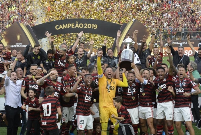 Players of Brazil's Flamengo celebrate on the podium with the trophy after winning the Copa Libertadores final football match by defeating Argentina's River Plate, at the Monumental stadium in Lima, on November 23, 2019. (Photo by Ernesto BENAVIDES / AFP)
