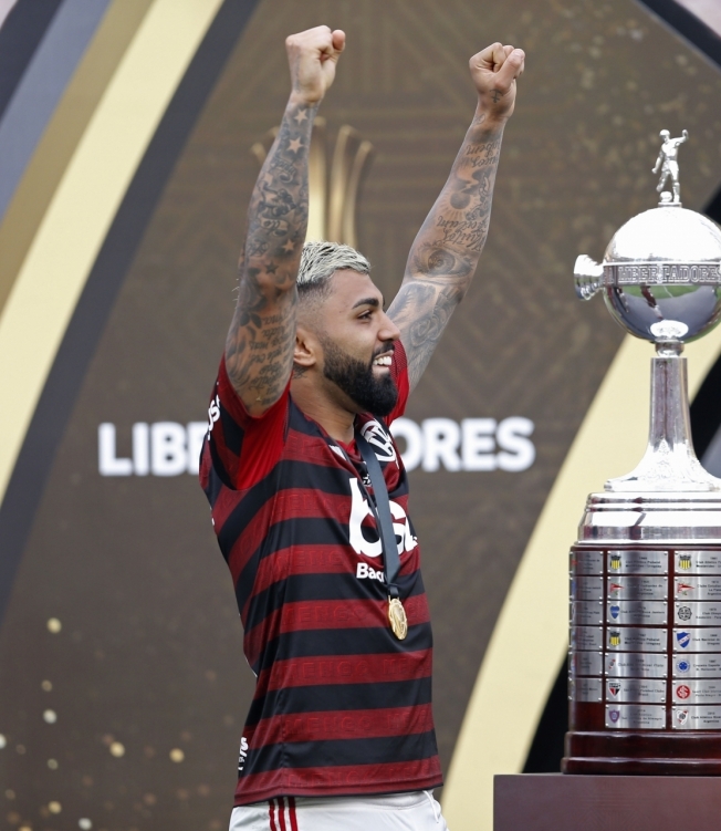 Flamengo's Gabriel Barbosa celebrates next to the trophy after winning the Copa Libertadores final football match by defeating Argentina's River Plate, at the Monumental stadium in Lima, on November 23, 2019. (Photo by Luka GONZALES / AFP)
