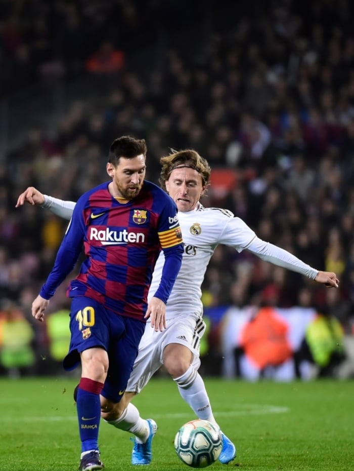 Barcelona's Argentine forward Lionel Messi vies with Real Madrid's Croatian midfielder Luka Modric during the 