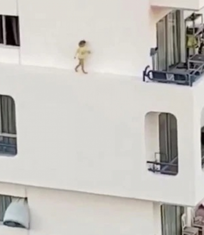 Criança correndo no parapeito do prédio