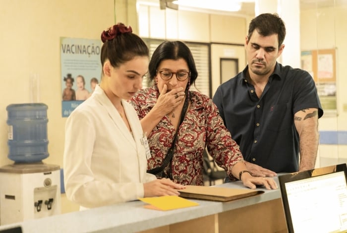 Betina (Isis Valverde) e Lurdes (Regina Casé) investigam livro de registros do hospital em que Domênico sumiu, em 'Amor de Mãe'