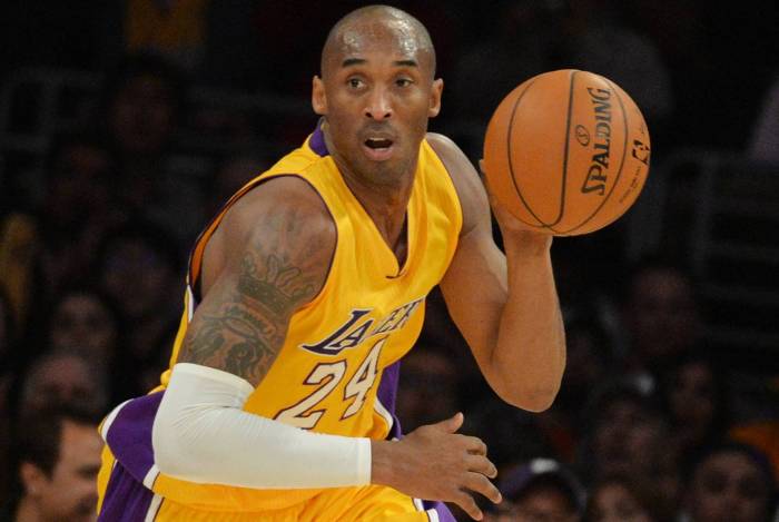 (FILES) In this file photo taken on January 02, 2015 Kobe Bryant of the Los Angeles Lakers drives against the Memphis Grizzlies during their NBA game 33 at the Staples Center in Los Angeles, California. - NBA legend Kobe Bryant died Sunday in a helicopter crash in suburban Los Angeles, celebrity website TMZ reported, saying five people are confirmed dead in the incident. (Photo by Mark RALSTON / AFP)