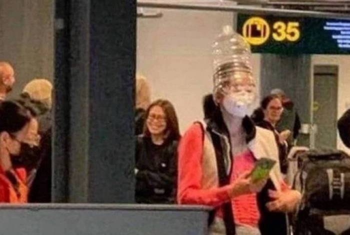 Mulher é vista com máscara cirúrgica e garrafa de plástico na cabeça por medo do coronavírus