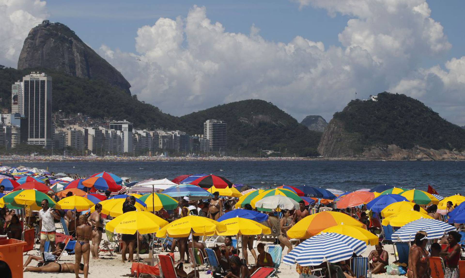 Cariocas e turistas aproveitam verão ensolarado no último domingo do ano durante preparativos para o Réveillon na praia de Copacabana.