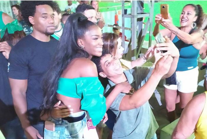 Iza força sorriso ao lado de folião