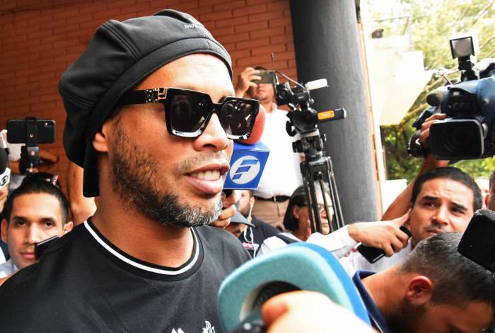 Ronaldinho é cercado por jornalistas ao deixar o prédio do MP