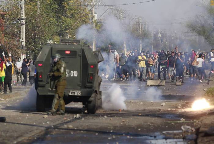 Manifestantes entram em conflito com a polícia de choque durante um protesto contra o governo do presidente chileno Sebastian Pinera em meio à pandemia do covid-19