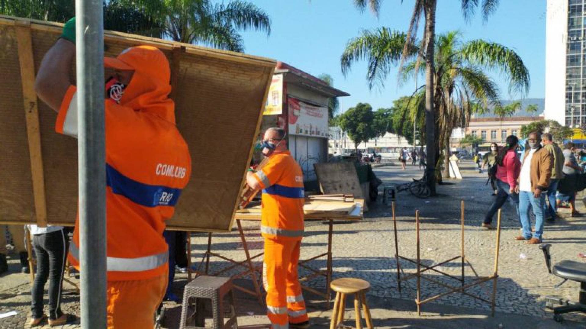 Funcionários da Comlurb desmontam barracas em ação contra comércio não essencial na Praça Procópio Ferreira, na Central do Brasil