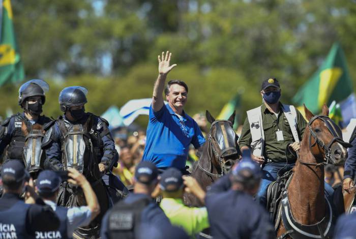 Montado em um cavalo da PM, Bolsonaro acena para manifestantes em frente ao Palácio do Planalto