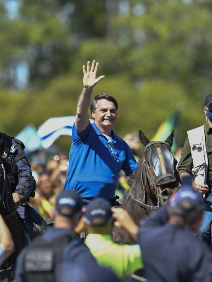 Montado em um cavalo da PM, Bolsonaro acena para manifestantes em frente ao Pal&aacute;cio do Planalto