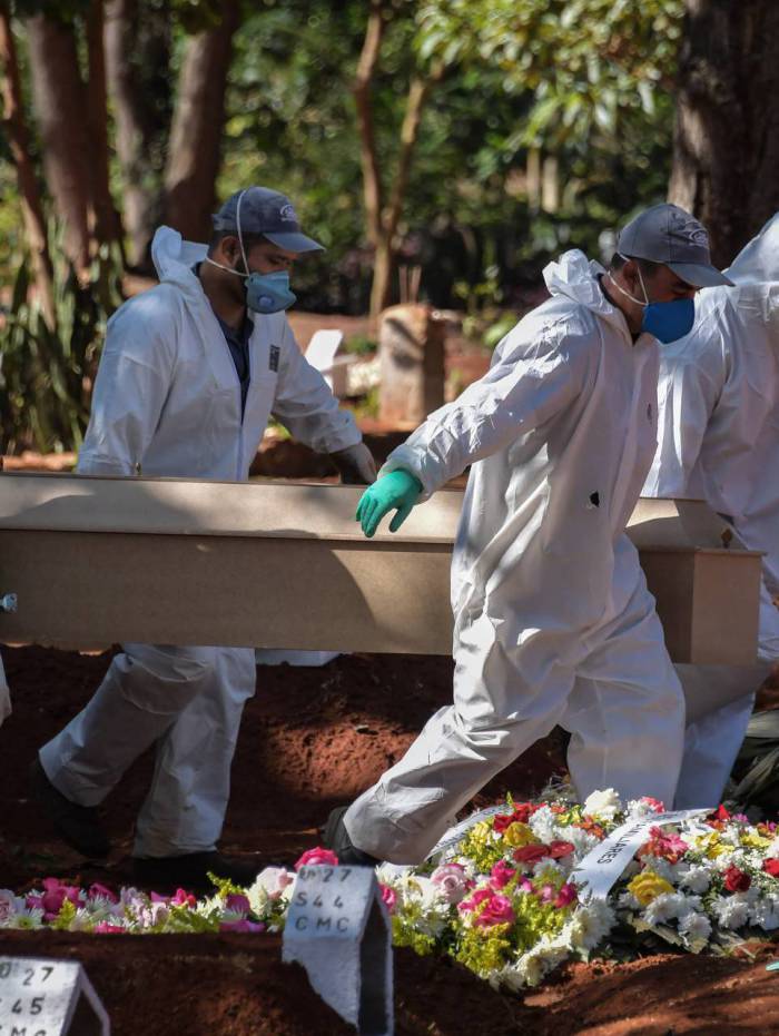 Funcion&aacute;rios do cemit&eacute;rio da Vila Formosa, em S&atilde;o Paulo, realizam o enterro de mais uma v&iacute;tima do coronav&iacute;rus
