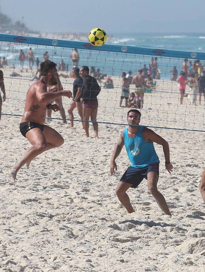 Banhistas jogando v&ocirc;lei na praia
