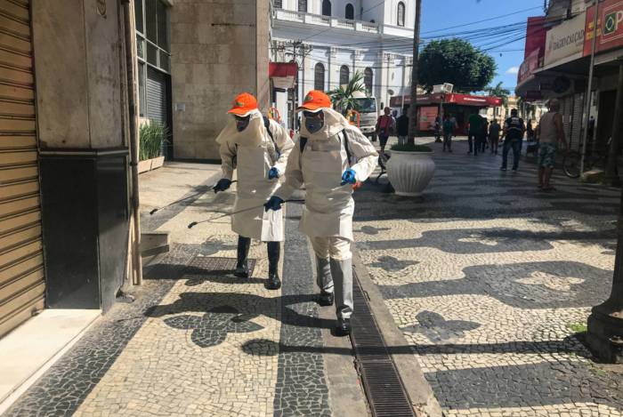 Homens da prefeitura fazem o trabalho de limpeza e higienização contra o coronavírus pelas ruas do Centro de Campos