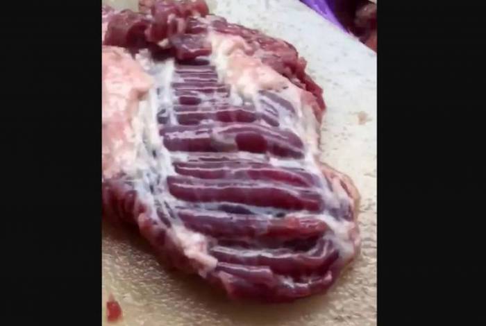 Pedaço de carne parecia pulsar em cima de tábua
