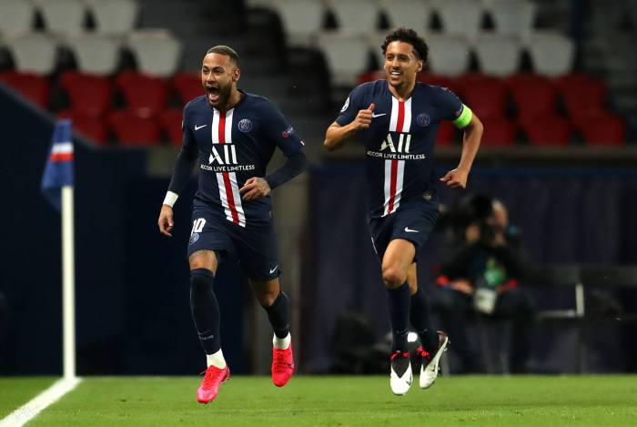 This handout photograph taken and released by the UEFA on March 11, 2020, shows Paris Saint-Germain's Brazilian forward Neymar (L) celebrating with Paris Saint-Germain's Brazilian defender Marquinhos after scoring a goal during the UEFA Champions League round-of-16 second leg football match between Paris Saint-Germain (PSG) and Borussia Dortmund at the Parc des Princes stadium in Paris. - The match is held behind closed doors due to the spread of COVID-19, the new coronavirus. (Photo by - / GETTY/UEFA / AFP) / RESTRICTED TO EDITORIAL USE - MANDATORY CREDIT 