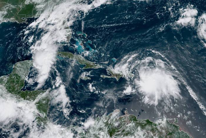 Imagem da Administração Oceânica e Atmosférica Nacional (NOAA) mostra a tempestade tropical Laura sobre Porto Rico e se aproximando do Haiti; e a tempestade tropical Marco entre Cuba e a Península de Yucatán