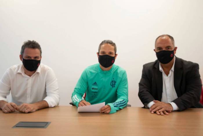 Diego, entre o diretor-executivo, Bruno Spindel, e o vice de futebol, Marcos Braz, assina a renovação de contrato

