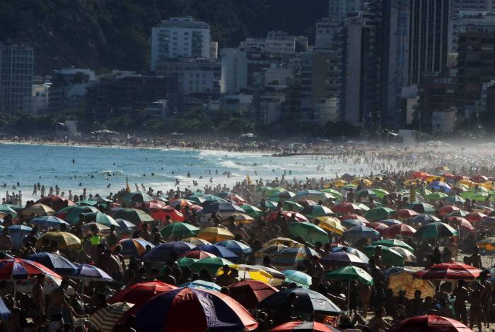 Uma cena de verão, em pleno inverno carioca durante a pandemia do novo coronavírus: aglomeração nas praias é o calcanhar de Aquiles do prefeito Crivella (no destaque)