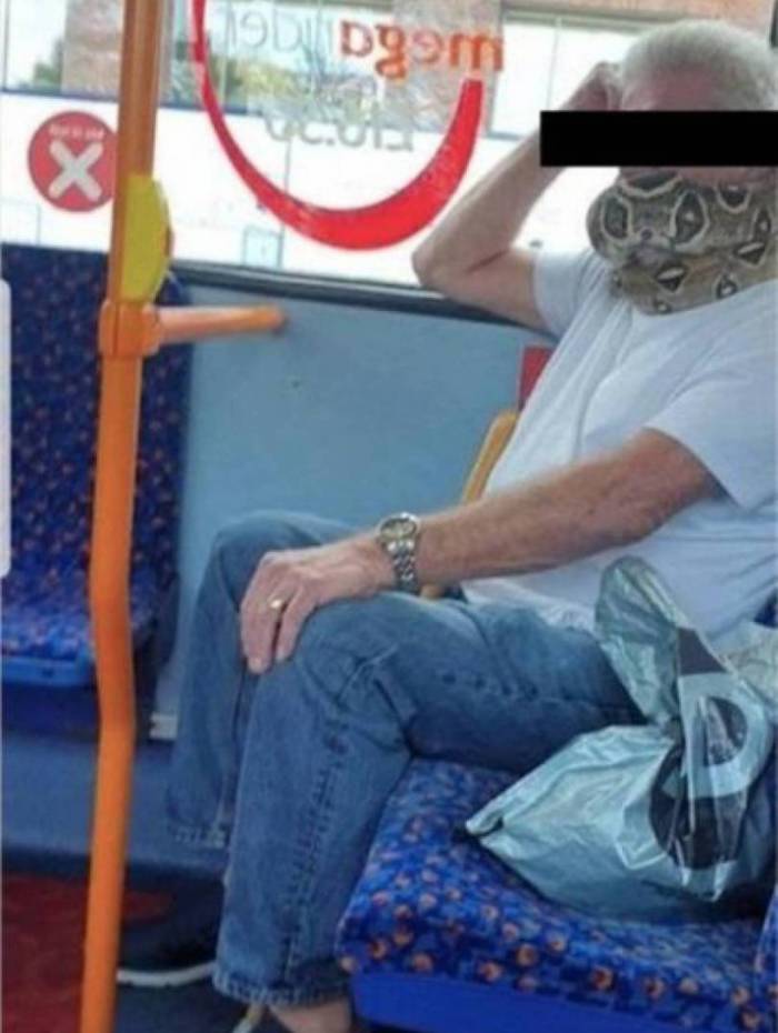Homem usa cobra para cobrir boca e nariz