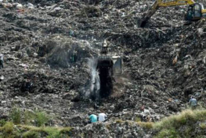 Equipes de resgate tentam encontrar uma menina soterrada sob o lixo na Índia
