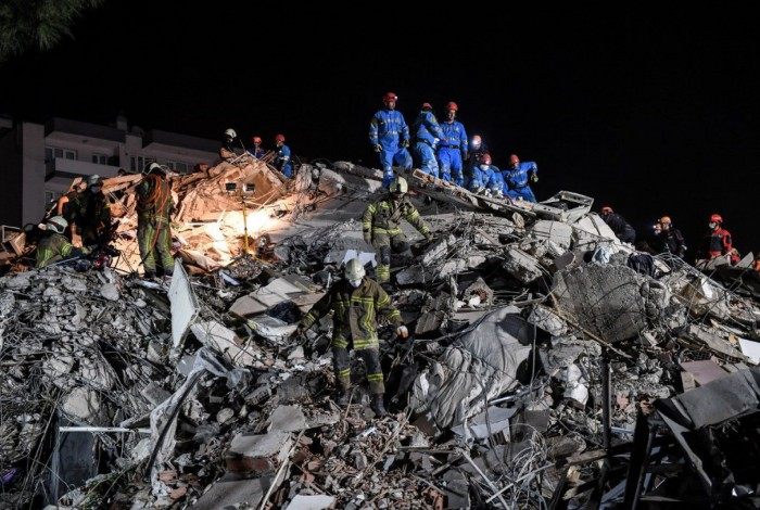 Em Bornova, socorristas, moradores e policiais tentavam abrir passagem entre os escombros de um prédio residencial de sete andares, com a ajuda de motosserras