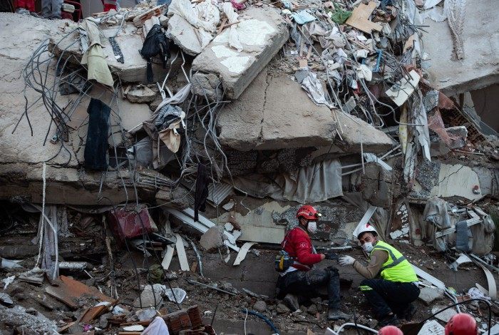 Volunteers and recue personnel search for survivors in a collapsed building in Izmir, on October 31, 2020, after a powerful earthquake struck Turkey's western coast and parts of Greece. - A powerful earthquake hit Turkey and Greece on October 30, killing at least six people, levelling buildings and creating a sea surge that flooded streets near the Turkish resort city of Izmir. (Photo by Yasin AKGUL / AFP)