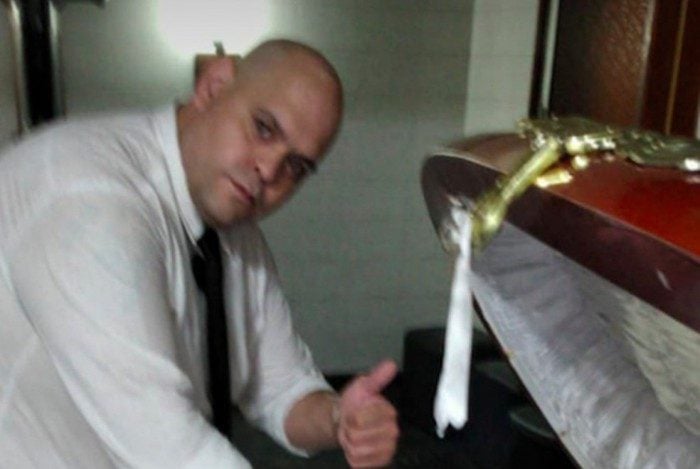 Funcionário tira foto ao lado do corpo de Maradona