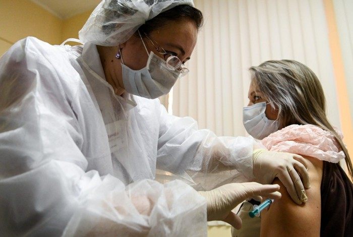 A nurse wearing a face mask proceeds to a vaccination against the coronavirus disease (COVID-19) by Sputnik V (Gam-COVID-Vac) vaccine at a clinic in Moscow on December 5, 2020, amid the ongoing coronavirus disease pandemic. - Russian President has told authorities to begin 