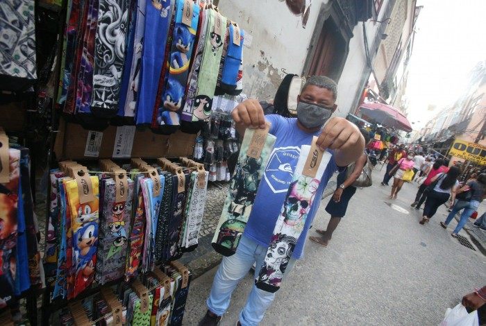 Vendedor Sebasti&atilde;o Moreira Barbosa mostra meias que custam R$25