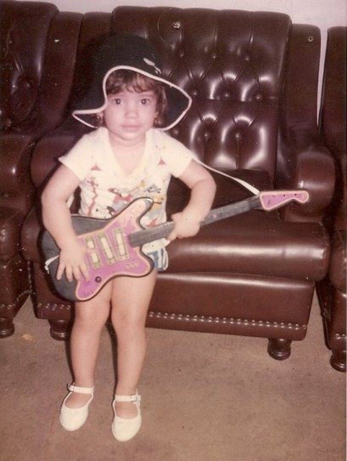 Renata Cabral com uma guitarra de brinquedo. Desde criança a menina já tinha vocação para a música