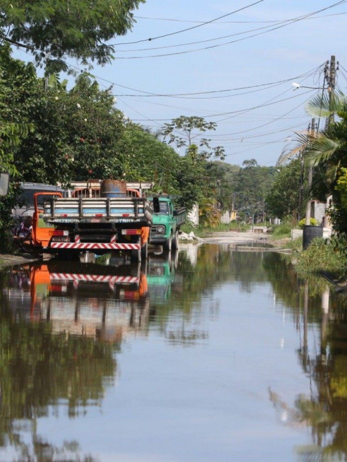 Em Imbariê, uma das regiões mais atingidas, morador da Rua Graça Aranha tenta tirar a água da calçada