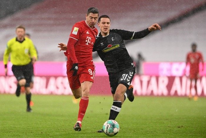 Bayern Munich's Polish forward Robert Lewandowski (L) and Freiburg's German defender Keven Schlotterbeck vie for the ball during the German first division Bundesliga football match between Bayern Munich and SC Freiburg in Munich, on January 17, 2021. (Photo by CHRISTOF STACHE / various sources / AFP) / DFL REGULATIONS PROHIBIT ANY USE OF PHOTOGRAPHS AS IMAGE SEQUENCES AND/OR QUASI-VIDEO