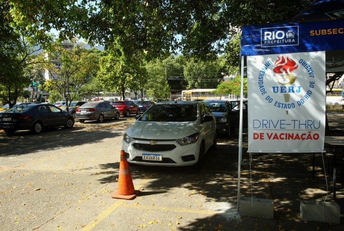 Vacinação drive - thru, por idade montado no estacionamento no estacionamento da UERJ. Na foto, fila de carros para o começo da vacinação. 
