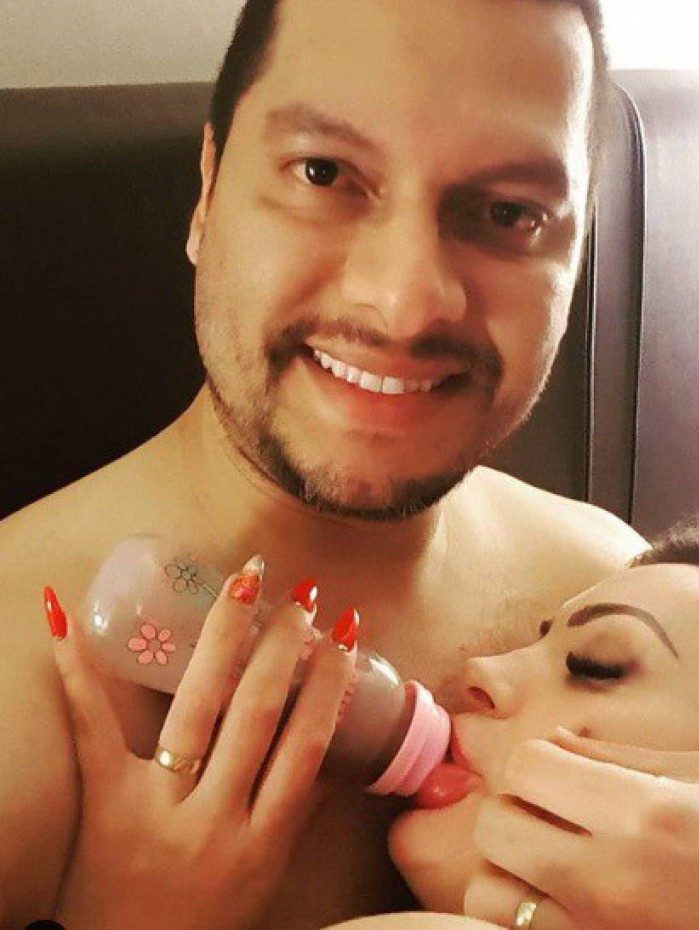 Andressa Urach volta a tomar leite na mamadeira, no colo do marido